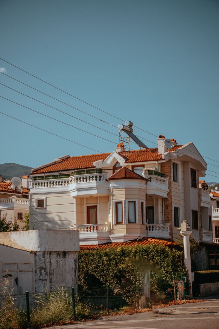 Elegant suburban villa featuring classic architecture under a clear blue sky, showcasing luxury living.